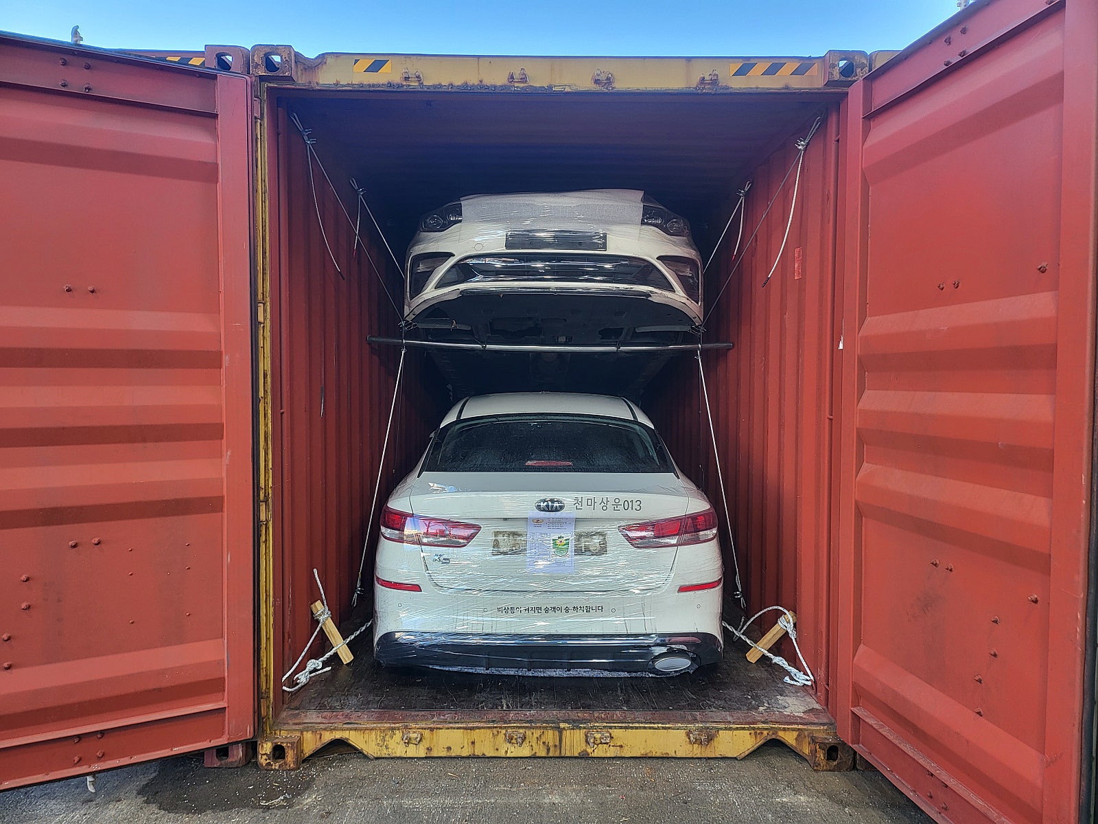 Kia K5 — أبيض — السيارة ومواد التثبيت داخل الحاوية