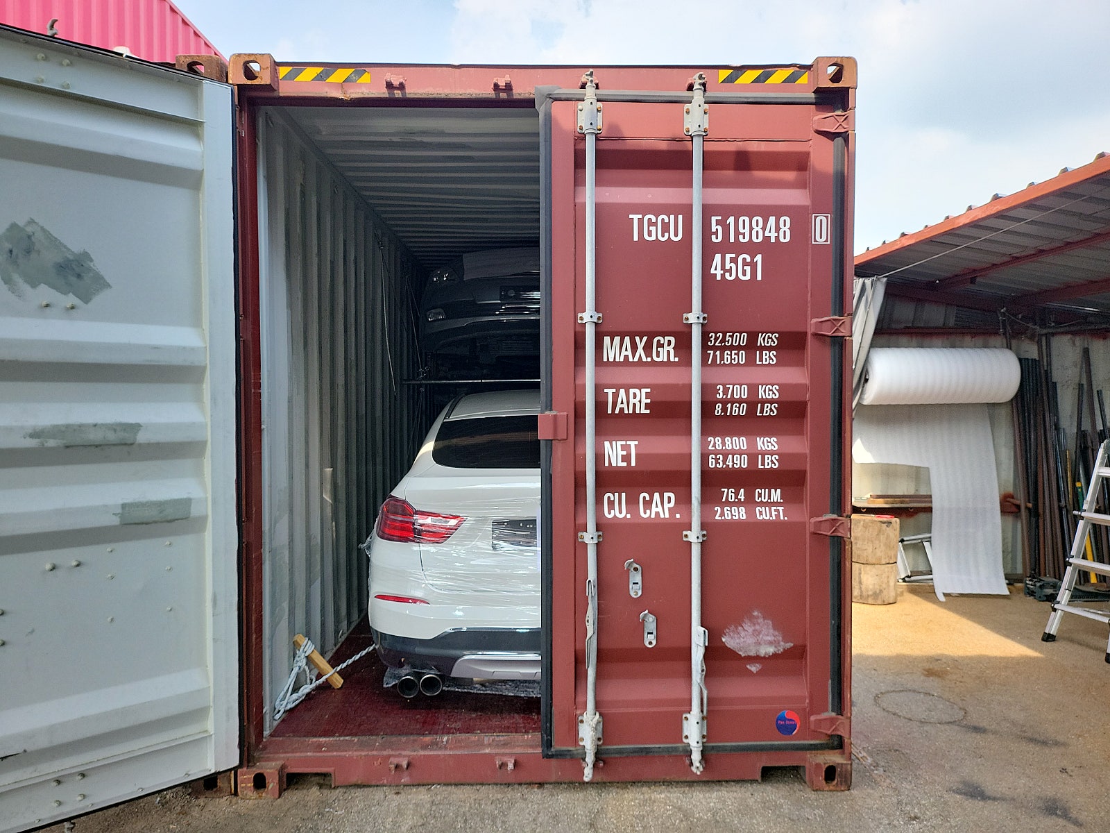 SUV كوبيه، اللون: أبيض، المؤخرة مثبتة داخل حاوية.
