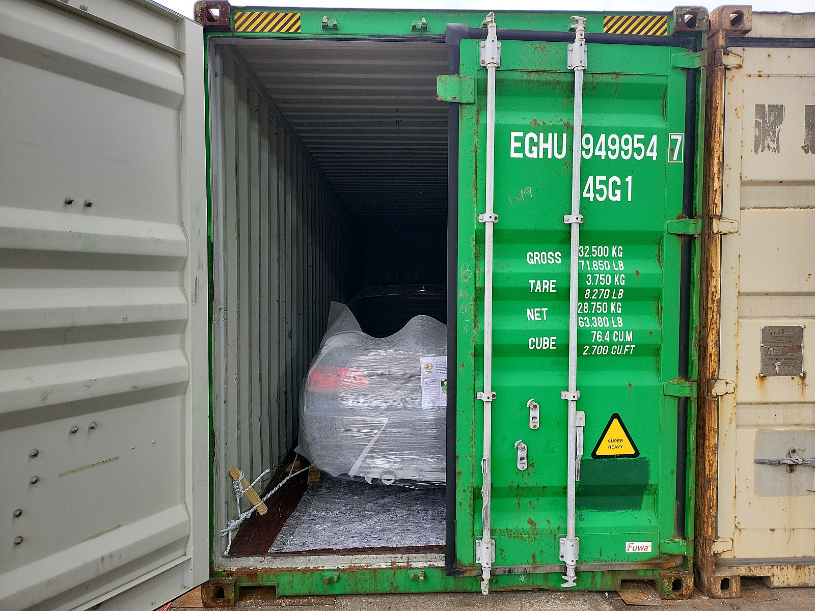 مؤخرة سيارة داخل حاوية وحبال تثبيت على الجانبين