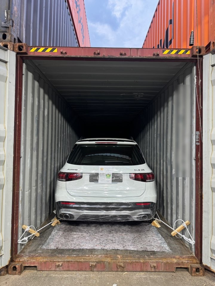 سيارة SUV، اللون: أبيض، المؤخرة مثبتة داخل حاوية.