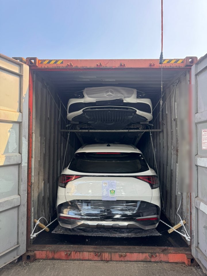 مؤخرة سيارة SUV بيضاء مغلفة تحت سيدان بيضاء مع حبال تثبيت.